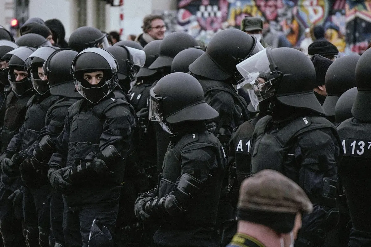 Mehrere Polizisten in Schutzausrüstung stehen dicht beieinander, bereit für einen Einsatz bei einer Demonstration oder einem Großereignis.
