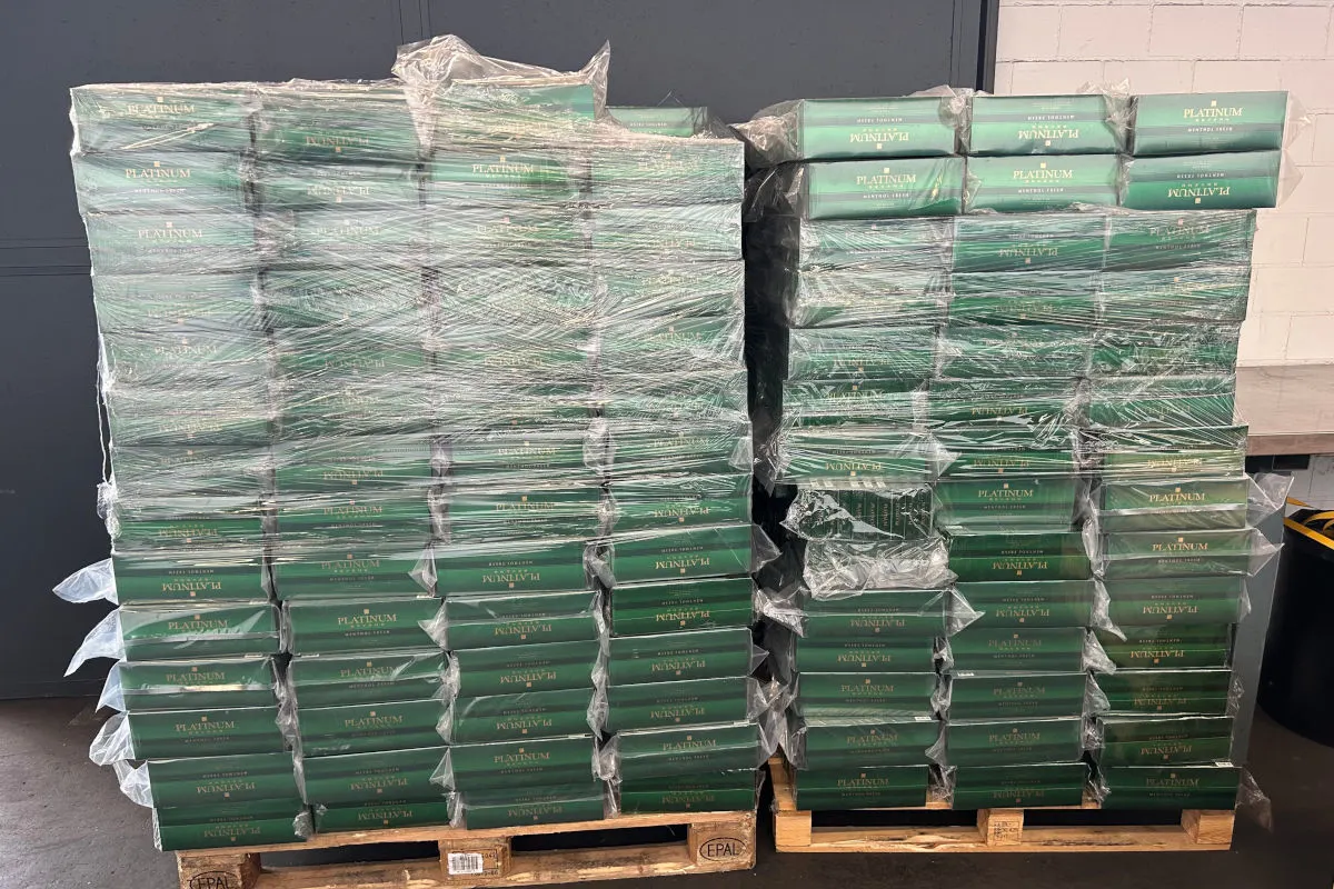 Zwei Paletten voller grüner Kartons, die mit Plastikfolie umwickelt sind. Die Kartons tragen die Aufschrift 'PLATINUM'.