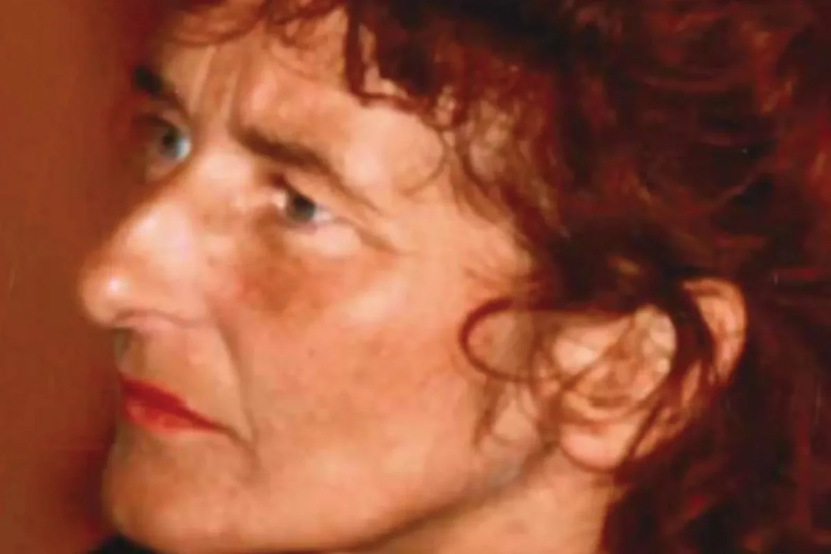 Nahaufnahme eines Gesichts mit roten Haaren und ernstem Blick, die Person schaut zur Seite.