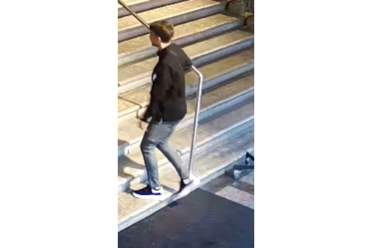 Eine männliche Person in dunkler Kleidung wird von einer Überwachungskamera erfasst, während sie eine Treppe hinaufgeht.