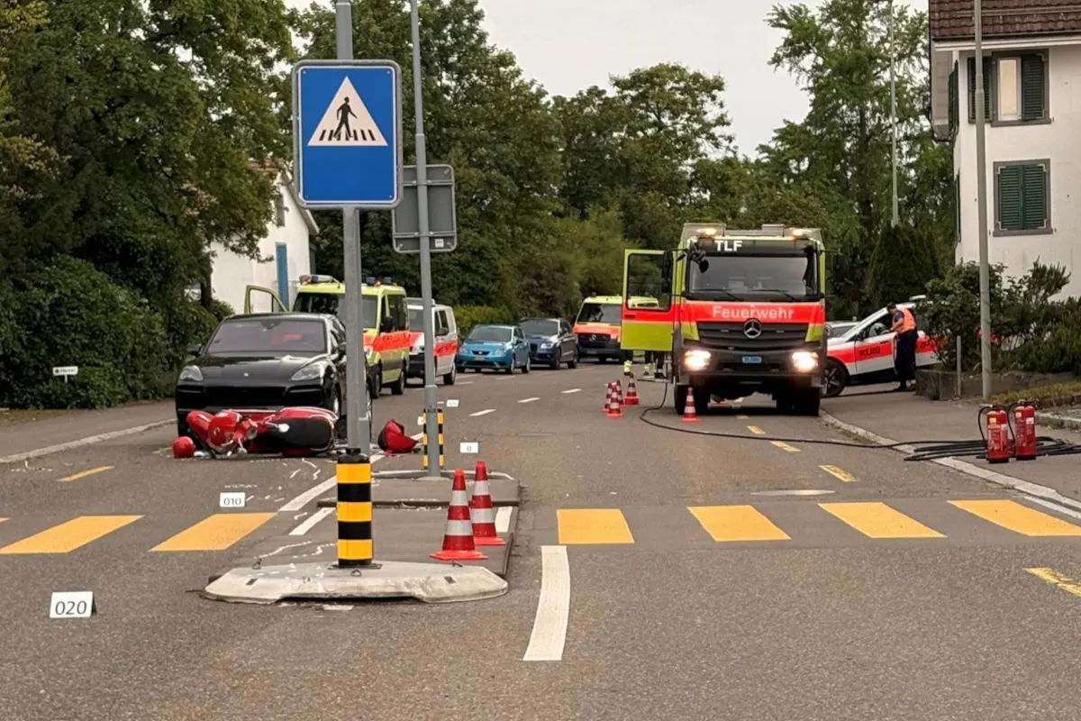Mehrere Einsatzfahrzeuge der Feuerwehr und Polizei stehen auf einer Straße. Ein schwarzes Auto und ein umgestürztes Motorrad sind zu sehen.