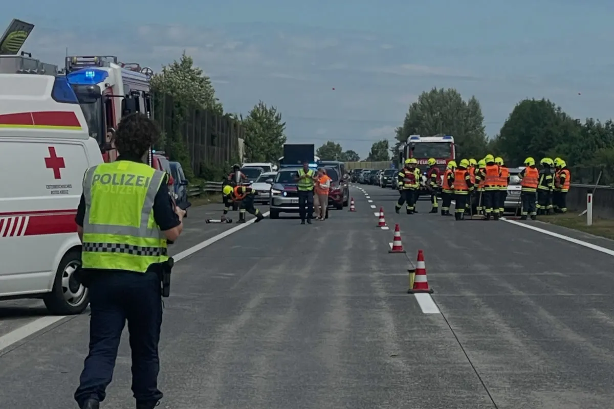 Auf der Autobahn sind Polizei- und Rettungsfahrzeuge sowie Feuerwehrleute zu sehen, die eine Absperrung bilden.
