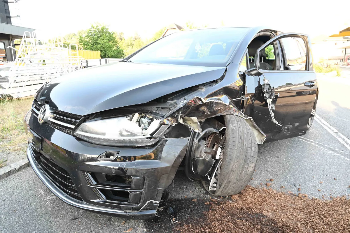 Das Bild zeigt einen schwarzen VW, dessen Vorderachse und Front stark beschädigt sind, möglicherweise nach einem Unfall.