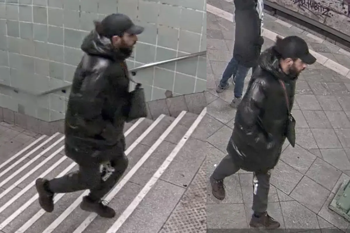Ein Mann, gekleidet in eine dunkle Jacke und Mütze, wird in einer U-Bahn-Station von einer Überwachungskamera erfasst.