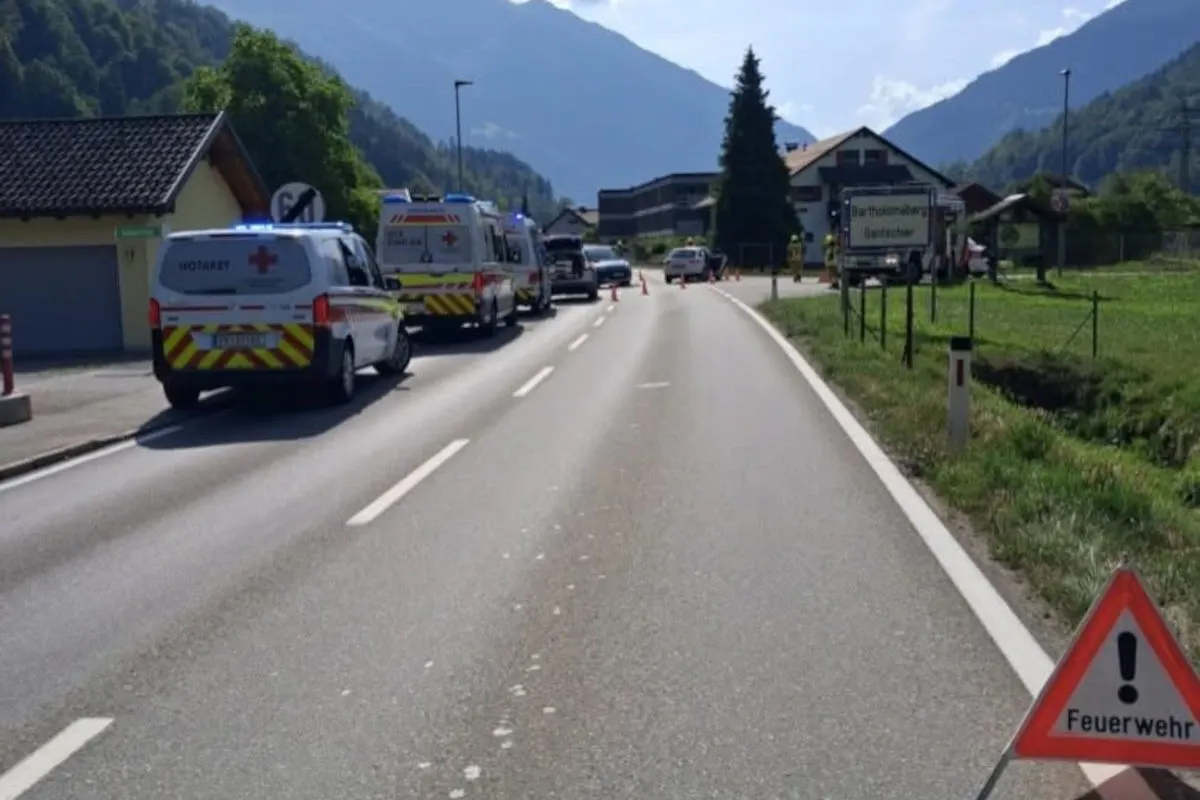 Mehrere Einsatzfahrzeuge, darunter Notarztwagen, stehen auf einer Landstraße. Ein Feuerwehrschild warnt vor der Einsatzstelle.