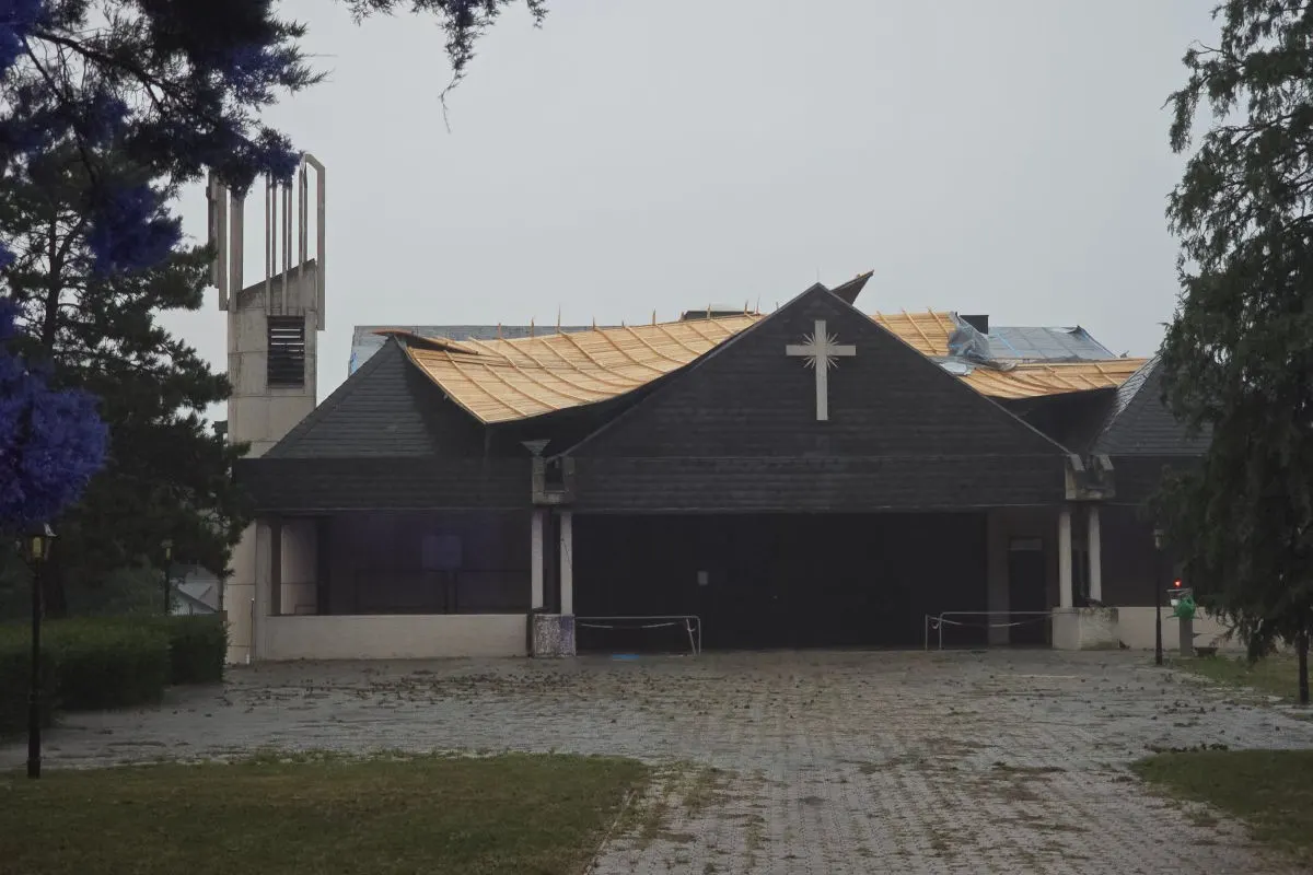 Ein Kirchengebäude mit einem teilweise abgedeckten Dach; ein Kreuz ist auf der Fassade sichtbar.