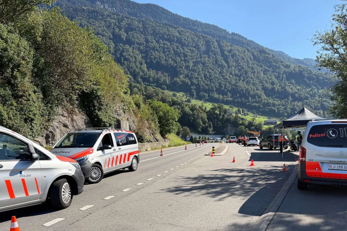 Mehrere Polizei-Transporter stehen an einer Landstraße in einer bergigen Gegend. Es sind Verkehrskegel und ein Zelt erkennbar, was auf eine Kontrolle hinweist. Die Umgebung ist sonnig und ländlich geprägt.