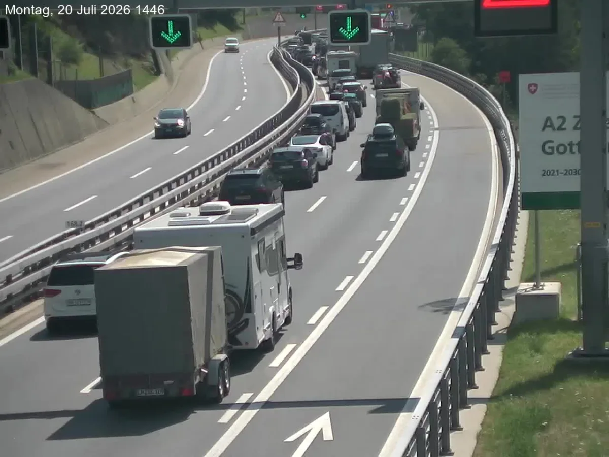Eine Reihe von Fahrzeugen stockt auf der A2 bei Gotthard. Schilder zeigen die Verkehrssituation an.