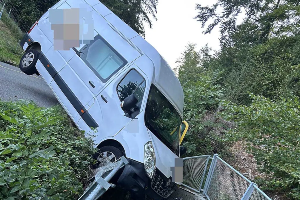 Ein weißer Van ist von der Straße abgekommen und seitlich an einer Böschung gegen ein Metallgeländer geprallt. Der Vorderteil des Fahrzeugs zeigt nach unten.