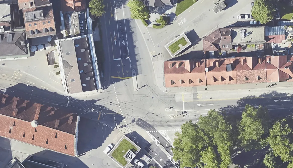 Detaillierte Luftaufnahme einer städtischen Straßenkreuzung mit mehreren Kreuzungen und umgebenden Gebäuden in einer Stadt.