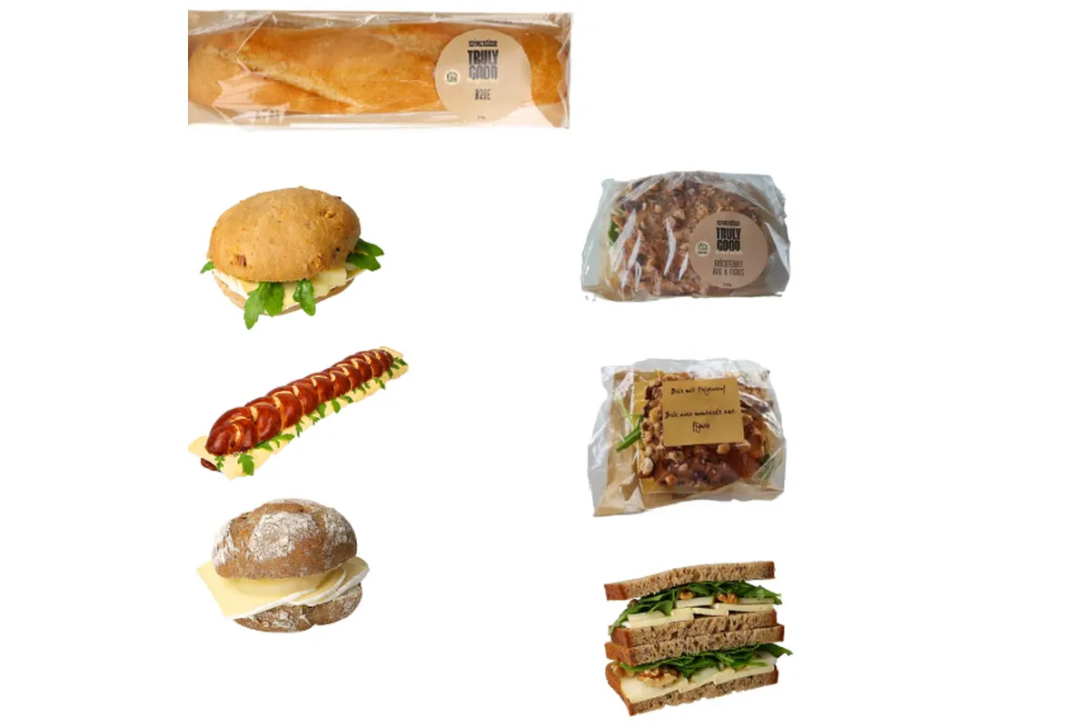 Das Bild zeigt verschiedene verpackte Sandwiches und Backwaren, schön angeordnet, auf einem weißen Hintergrund.