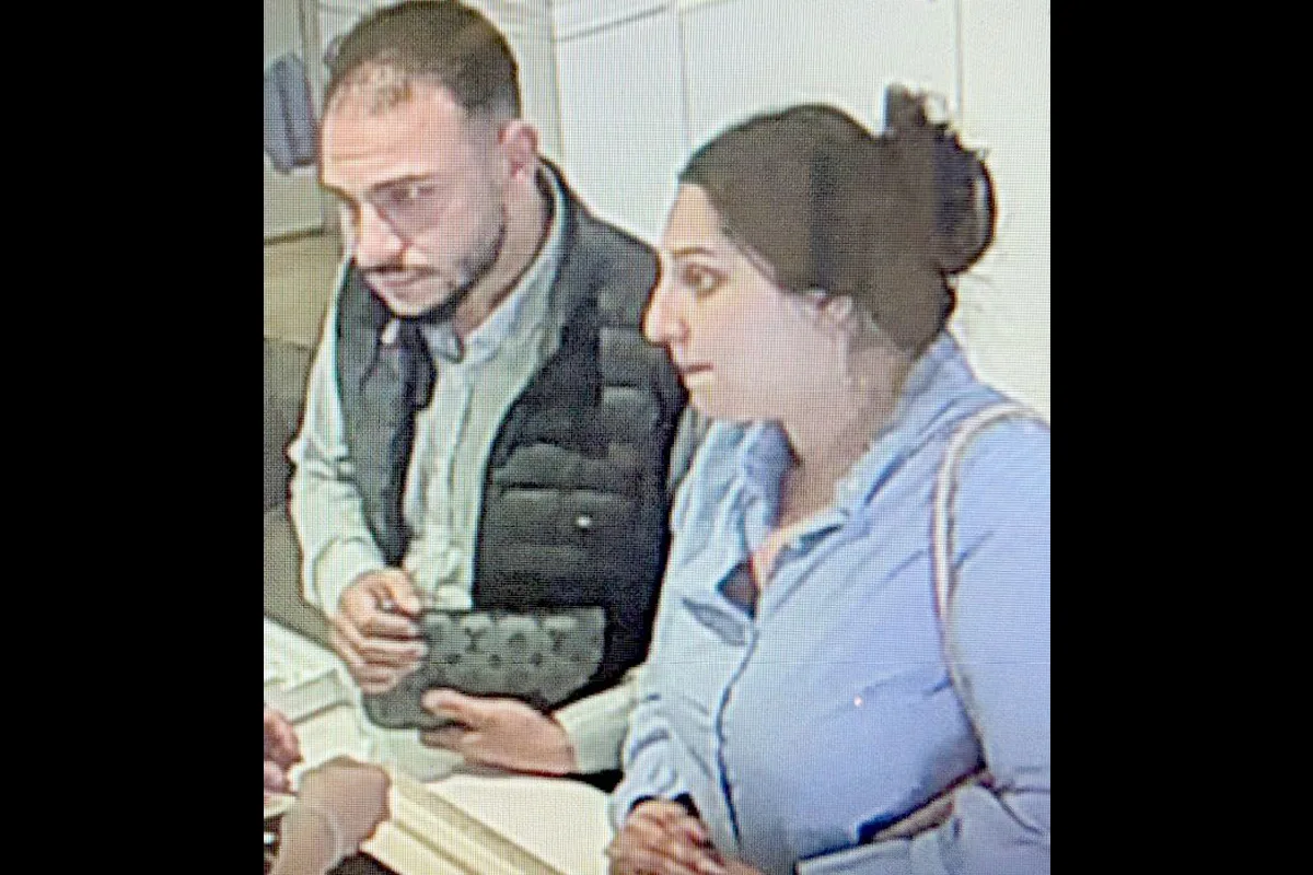 Das Bild einer Überwachungskamera zeigt zwei Personen, die an einem Schalter stehen. Beide sind in alltäglicher Kleidung.