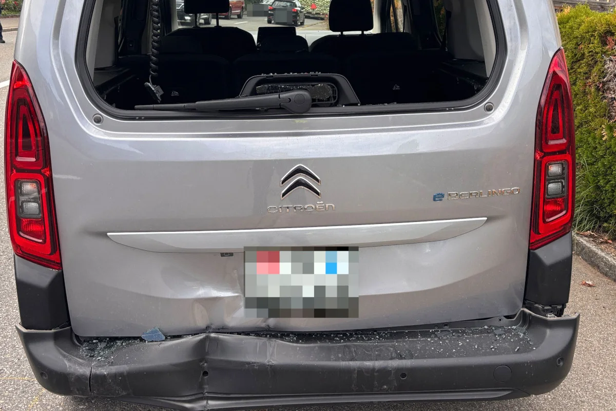 Das Bild zeigt das beschädigte Heck eines silbernen Citroën Berlingo mit einer eingedrückten Stoßstange und zerbrochenem Glas.