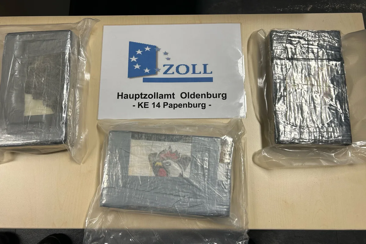 Mehrere in Folie verpackte Pakete liegen auf einem Tisch, begleitet von einem Schild des Hauptzollamts Oldenburg, KE 14 Papenburg.