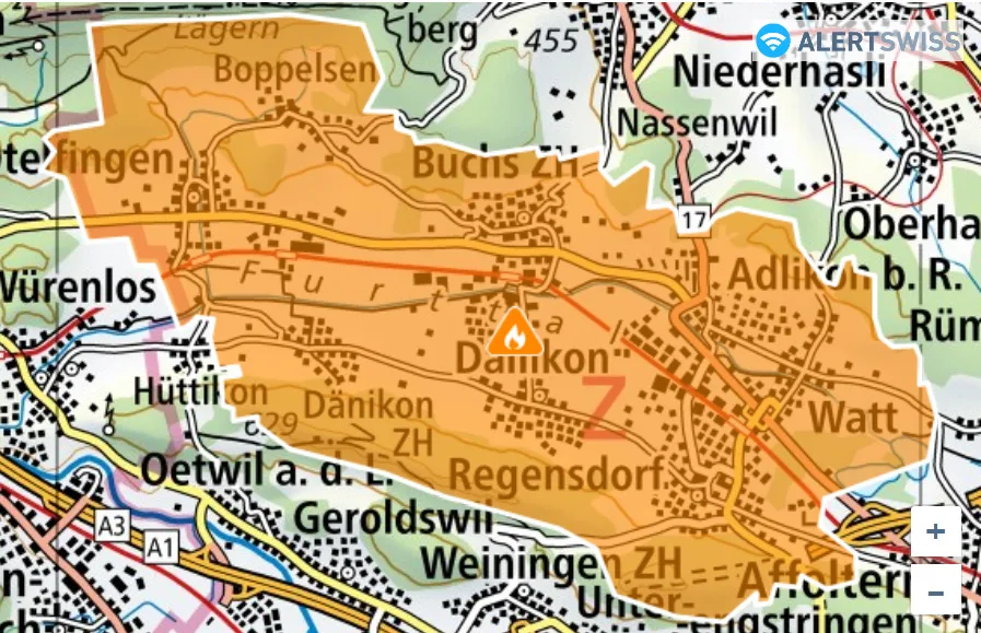 Eine Landkarte zeigt das Gebiet um Dänikon im Kanton Zürich, das in Orange markiert ist. Ein Warnsymbol ist zu sehen.