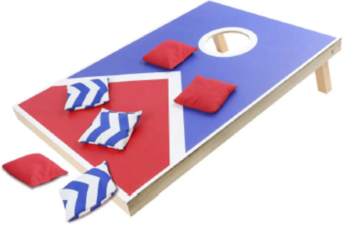Ein Cornhole-Spielbrett ist sichtbar, auf dem mehrere kleine rote und blau-weiß gemusterte Kissen liegen, einige daneben.