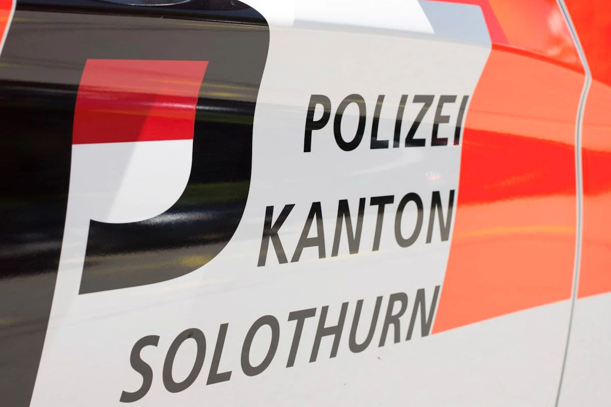 Das Bild zeigt eine Nahaufnahme der Seitenbeschriftung eines Polizeifahrzeugs. Die Wörter 'Polizei', 'Kanton', und 'Solothurn' sind gut sichtbar, zusammen mit einem roten und weißen Farbschema.
