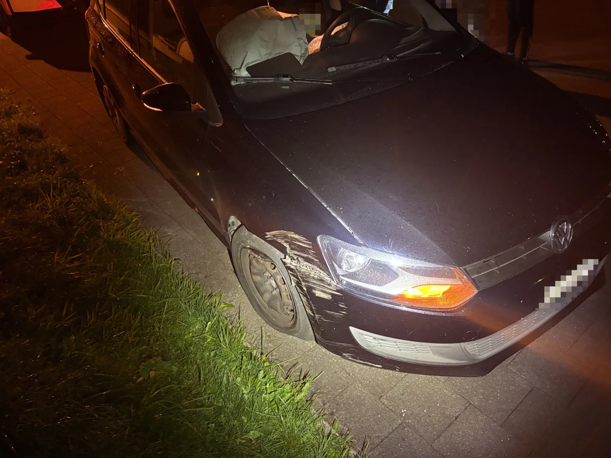 Ein schwarzer VW-Polo mit sichtbaren Schäden an der Front steht nachts am Straßenrand. Das Abblendlicht ist eingeschaltet und der Airbag im Fahrzeuginneren ist ausgelöst.