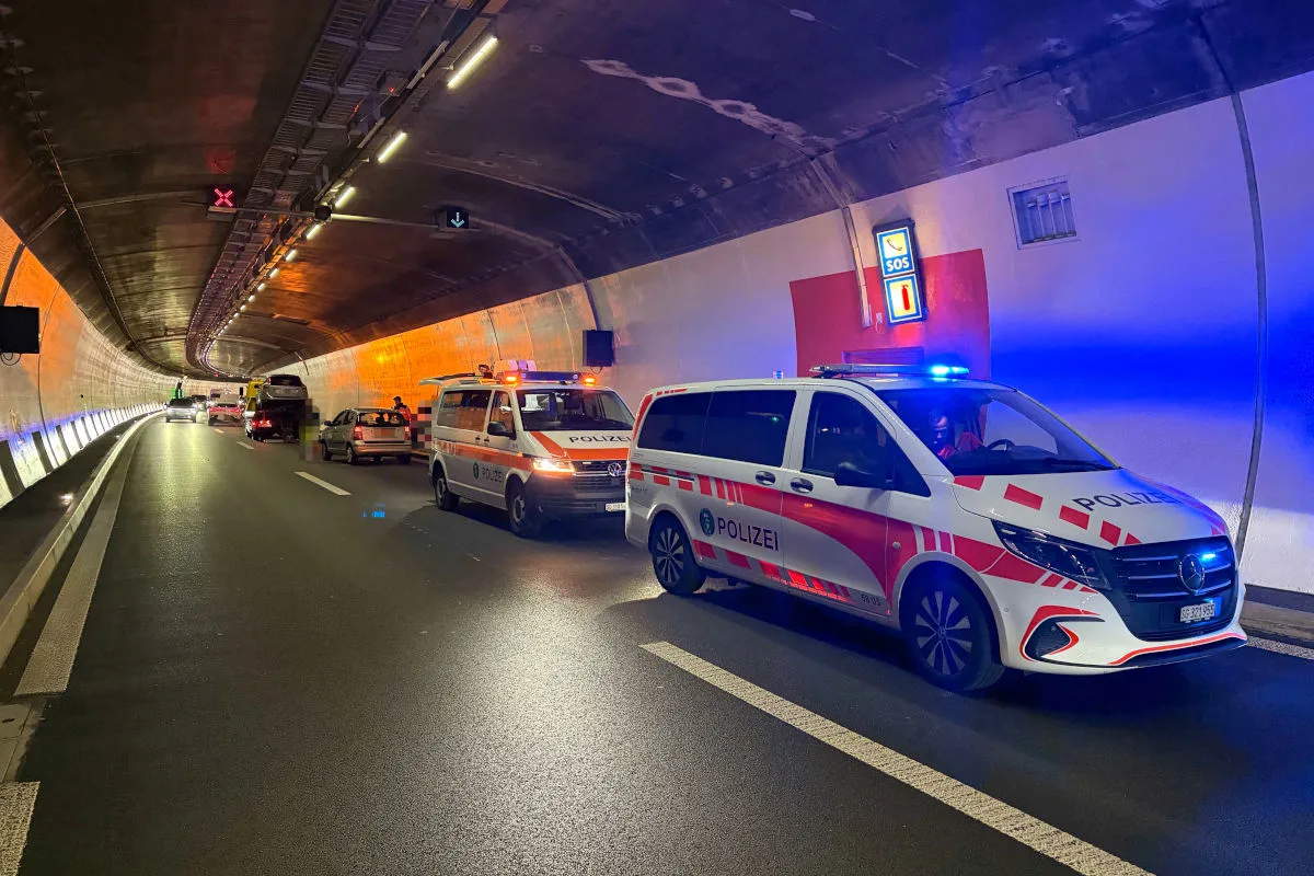 Zwei Polizeifahrzeuge mit eingeschaltetem Blaulicht stehen in einem Tunnel. Eine Fahrspur ist gesperrt und ein Fahrzeug wird abgeschleppt.