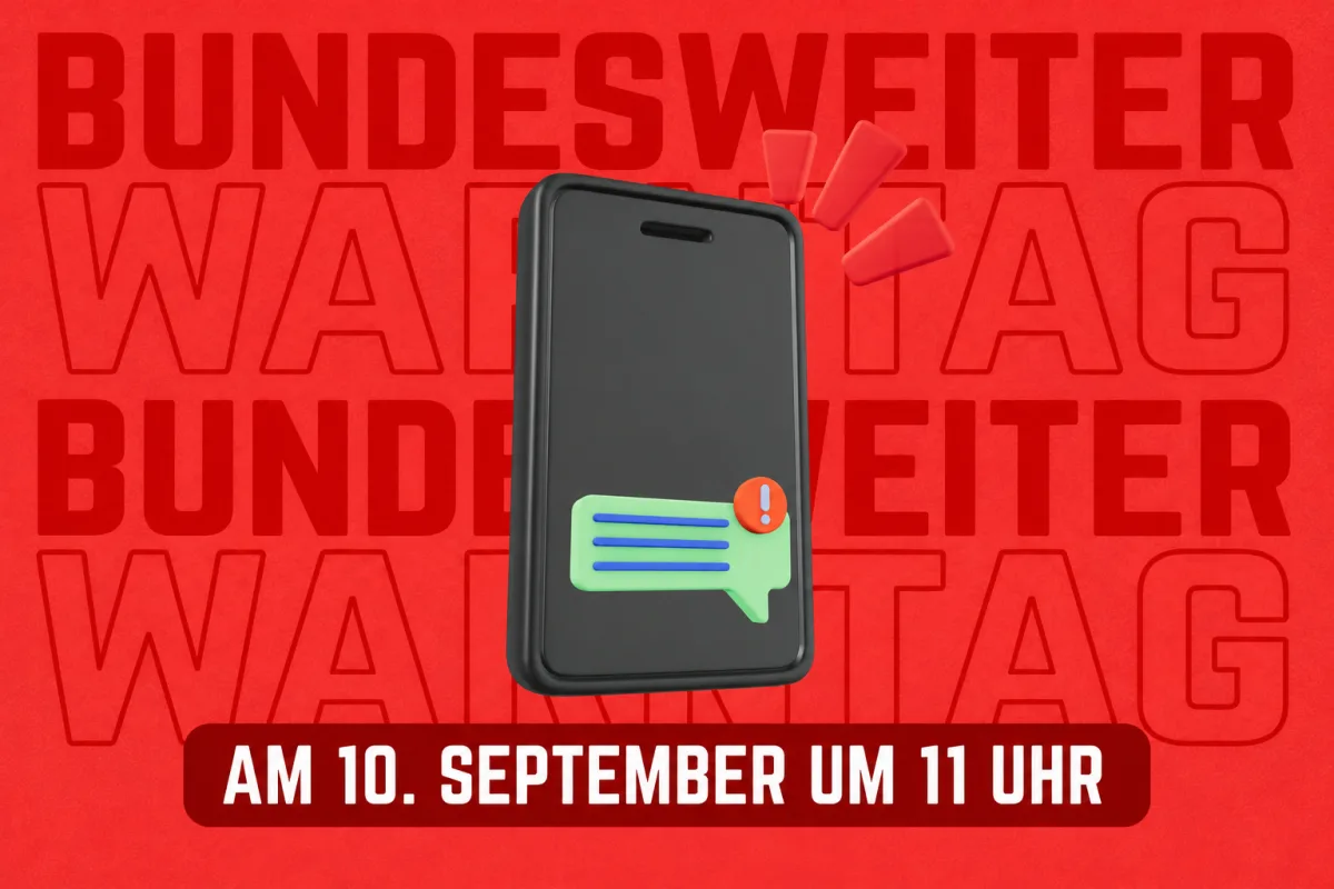 Ein Smartphone zeigt ein Benachrichtigungssymbol vor einem roten Hintergrund mit dem Text 'Bundesweiter Warntag am 10. September um 11 Uhr'.
