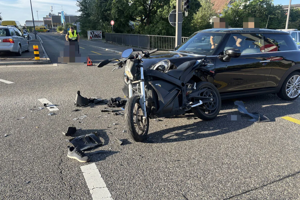 Ein Motorrad und ein beschädigtes Auto sind auf einer städtischen Straße zu sehen, umgeben von Trümmern.
