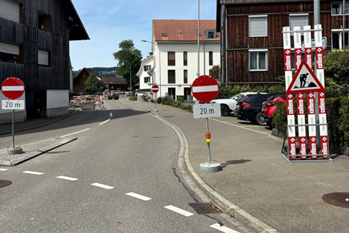 Eine Straße ist durch mehrere Verkehrsschilder und Absperrungen wegen Bauarbeiten gesperrt. Im Hintergrund sind Gebäude zu sehen.