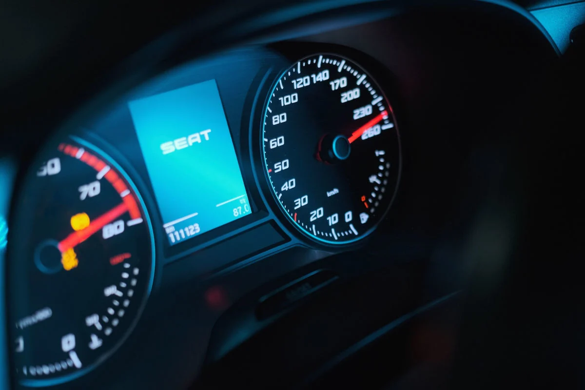 Das Bild zeigt einen Tachometer mit einer digitalen Anzeige bei Nacht. Die Anzeige zeigt den Schriftzug SEAT und ist beleuchtet.