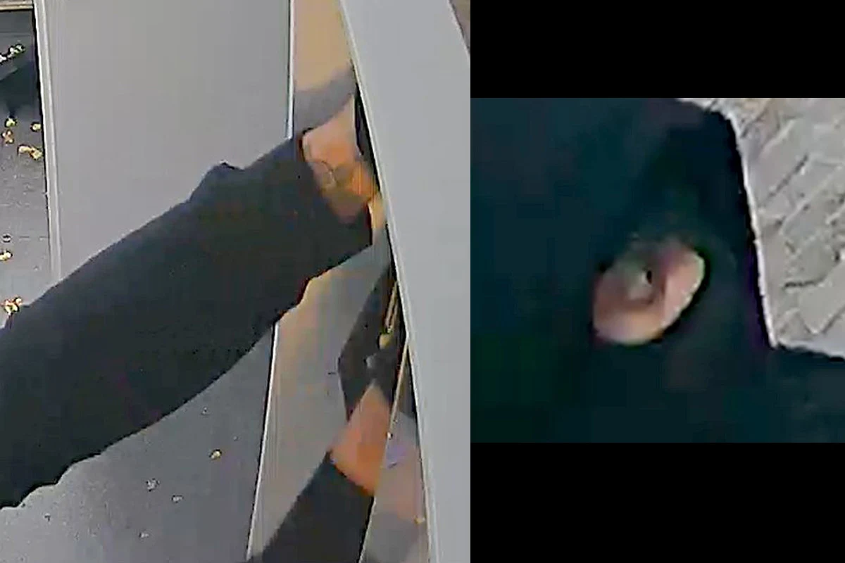 Eine maskierte Person versucht, mit einem Werkzeug ein Gerät zu manipulieren. Der Fokus liegt auf den Händen und dem vermummten Gesicht.