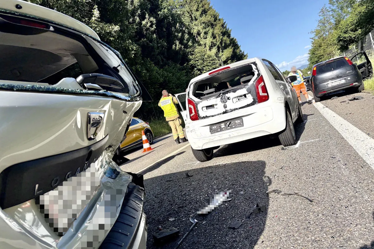 Mehrere stark beschädigte Fahrzeuge stehen auf einer Autobahnspur. Einsatzkräfte sind im Hintergrund sichtbar.