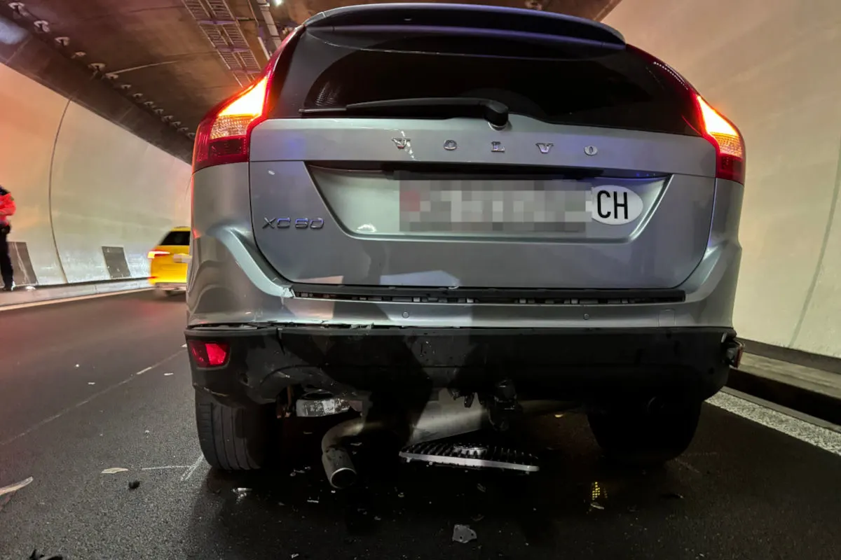 Das Bild zeigt das Heck eines Volvo XC60 mit sichtbaren Schäden in einem Tunnel. Ein weiterer Wagen und eine Person sind im Hintergrund erkennbar.