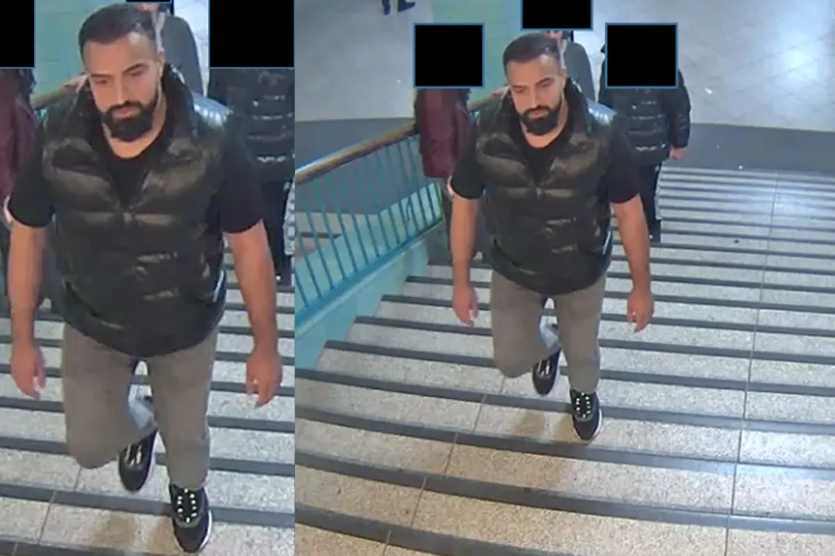 Ein Mann mit Bart, schwarzer Weste und grauer Hose steigt eine Treppe in einer U-Bahn-Station hinauf. Andere Personen sind im Hintergrund zu sehen.