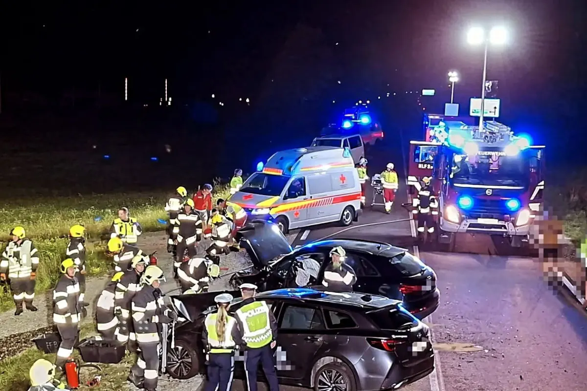 Bei Nacht sind Einsatzkräfte der Feuerwehr, Polizei und Rettungsdienste an einem Unfallort mit zwei Fahrzeugen auf einer Straße.