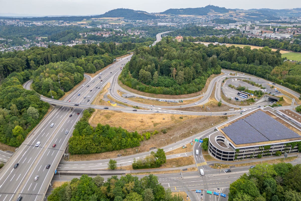 Eine Luftaufnahme zeigt ein Autobahnkreuz mit mehreren Fahrspuren und umgebender Vegetation. Es sind keine Fahrzeuge der Einsatzkräfte zu sehen.