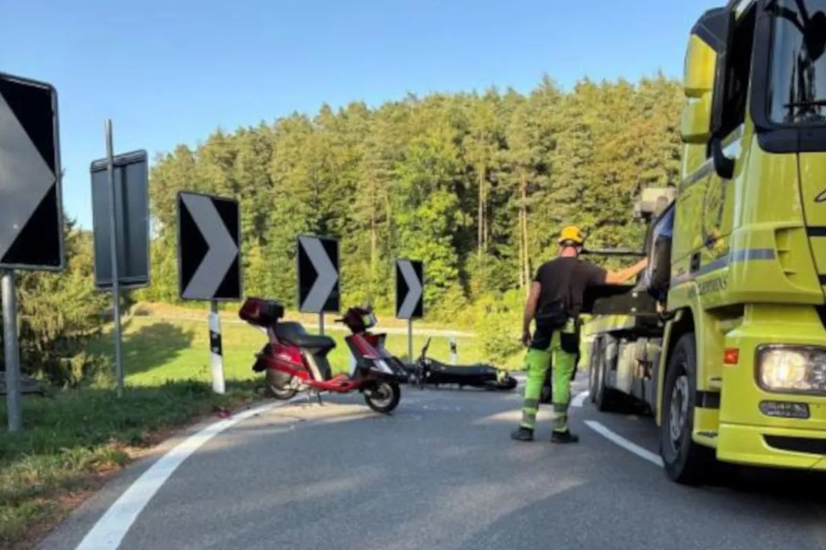 Ein rotes Motorrad liegt umgestürzt auf einer kurvigen Straße, flankiert von einem größeren Abschleppwagen und zahlreichen Verkehrsschildern.