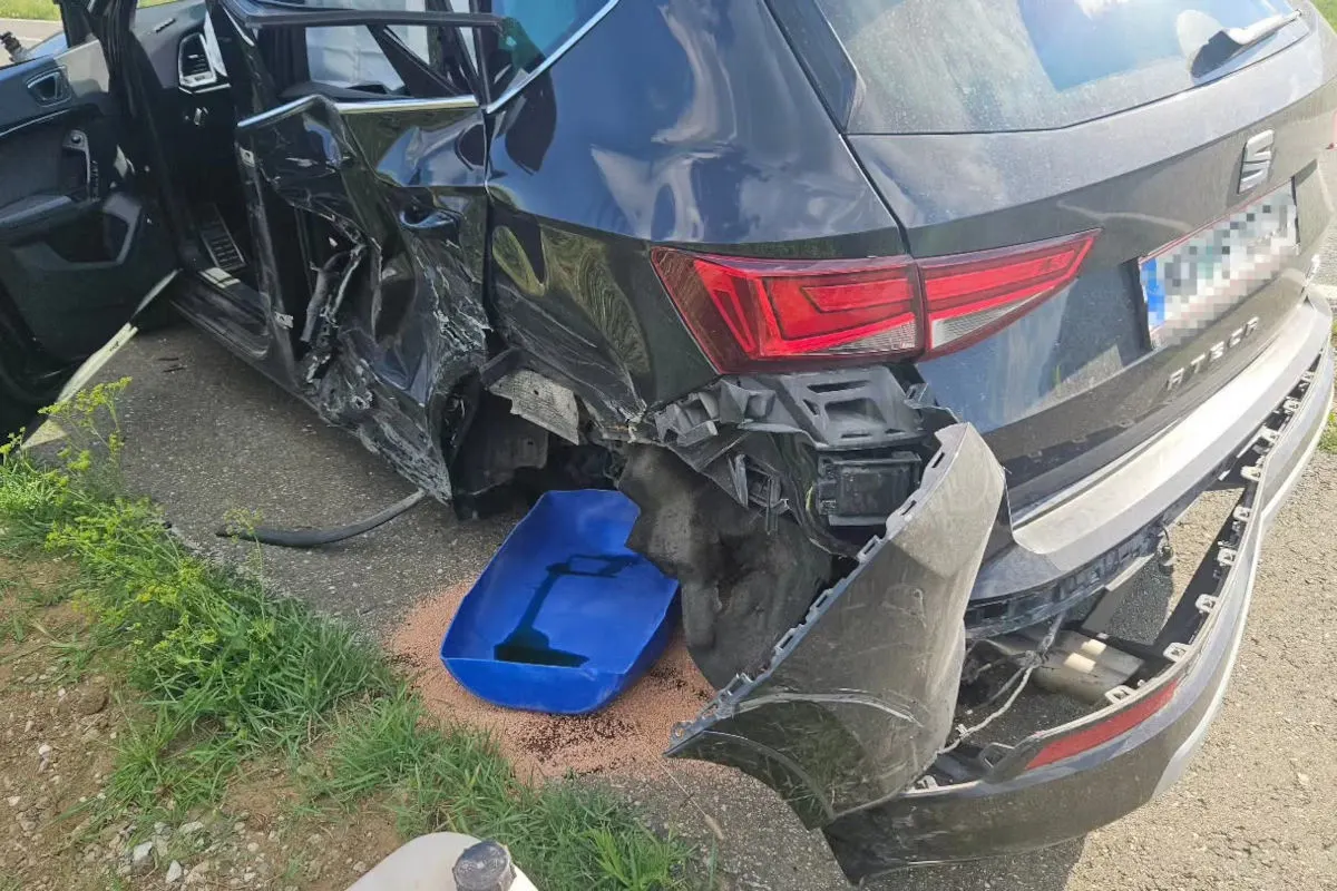 Ein schwarzer SUV hat erhebliche Schäden auf der Fahrerseite und am hinteren Kotflügel. Der Innenraum des Wagens ist teilweise sichtbar.