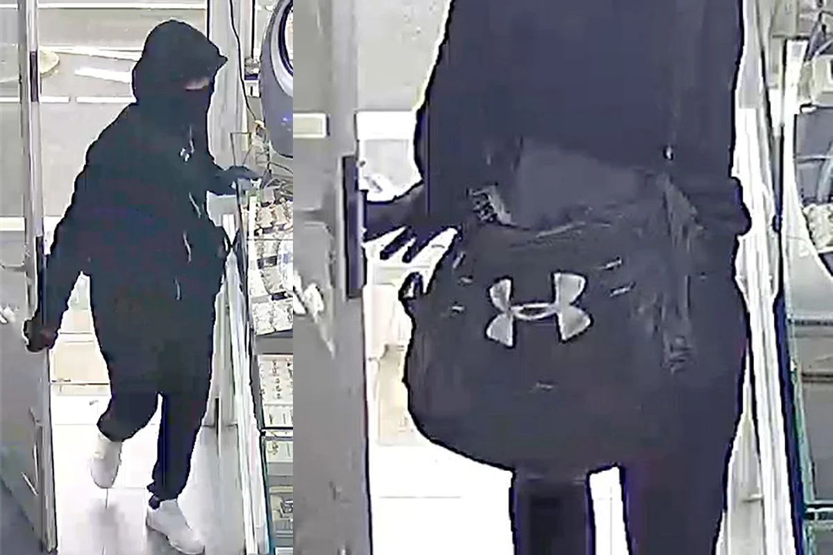 Eine maskierte Person in dunkler Kleidung mit Kapuze betritt ein Geschäft, in der linken Hand eine Tasche mit Logo.
