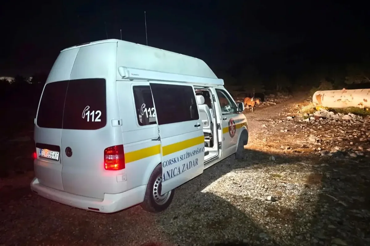 Ein weißer Van mit der Aufschrift 'Gorska služba spašavanja Zadar' am Straßenrand bei Nacht. Im Hintergrund sind Pferde zu sehen.