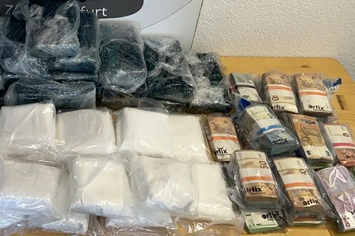 Auf einem Tisch liegen mehrere Drogenpäckchen und Bargeldbündel, jeweils in Plastikbeuteln verpackt.