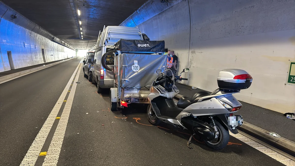 Ein Transporter mit Anhänger und ein Motorrad stehen im Tunnel. Personen sind sichtbar, die Fahrzeuge untersuchen.