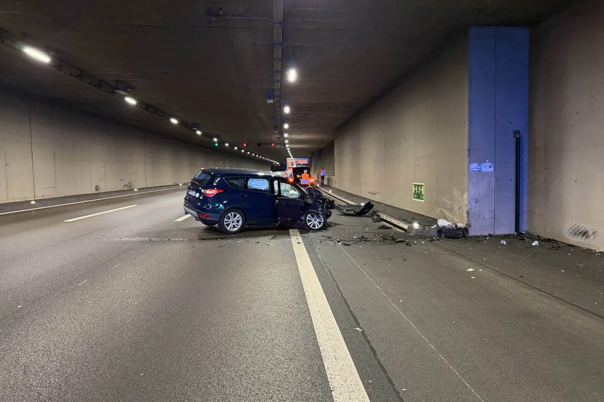 Ein dunkelblauer Pkw steht schwer beschädigt und frontal eingedrückt in einem Tunnel. Die Fahrbahn ist mit Trümmern übersät.