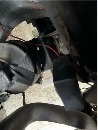 Detailansicht eines Fahrzeugmotors mit sichtbaren Kabeln und Bauteilen. Verschiedene Komponenten sind nah beieinander installiert.