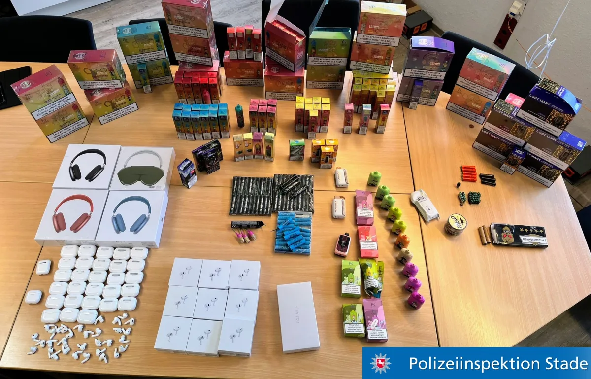 Verschiedene Konsumartikel, darunter Boxen und Packungen, sind zusammen mit Elektronik wie Kopfhörern ordentlich auf einem Tisch angeordnet.