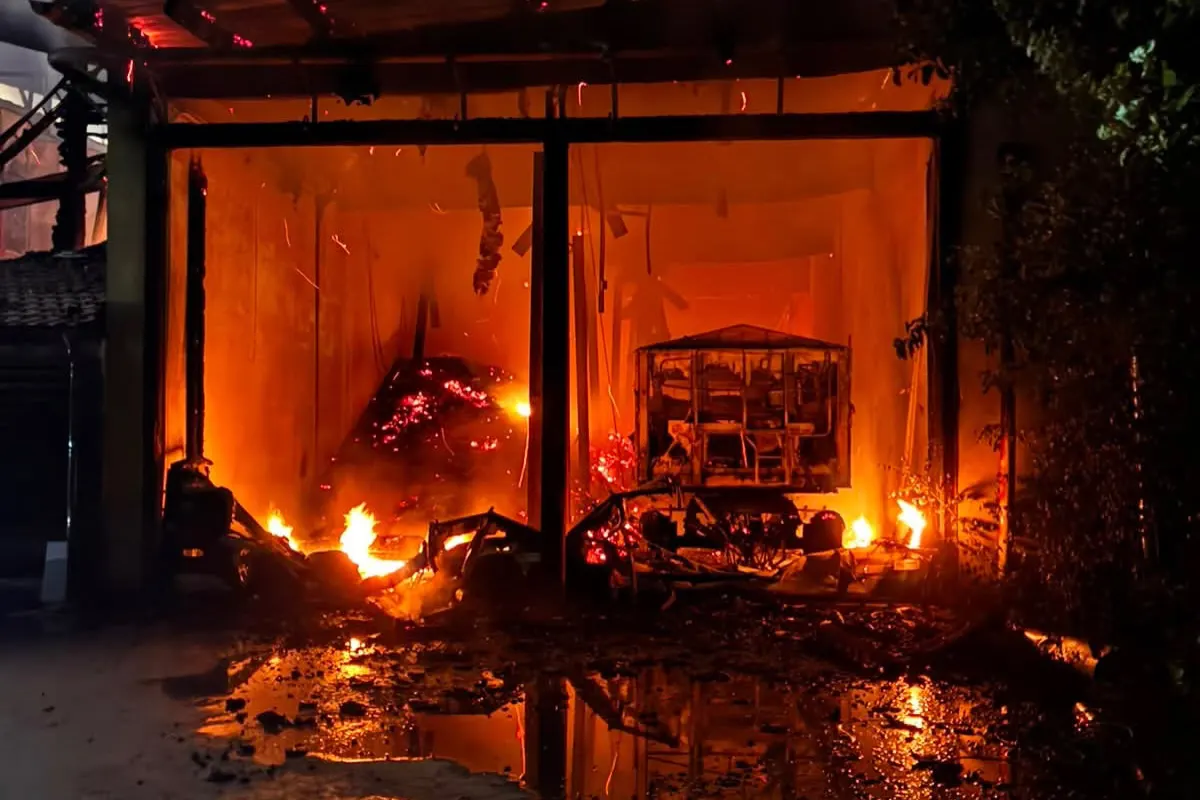 In einem Gebäude brennen ein Fahrzeug und es gibt starke Rauchentwicklung. Flammen und Glut sind deutlich sichtbar.
