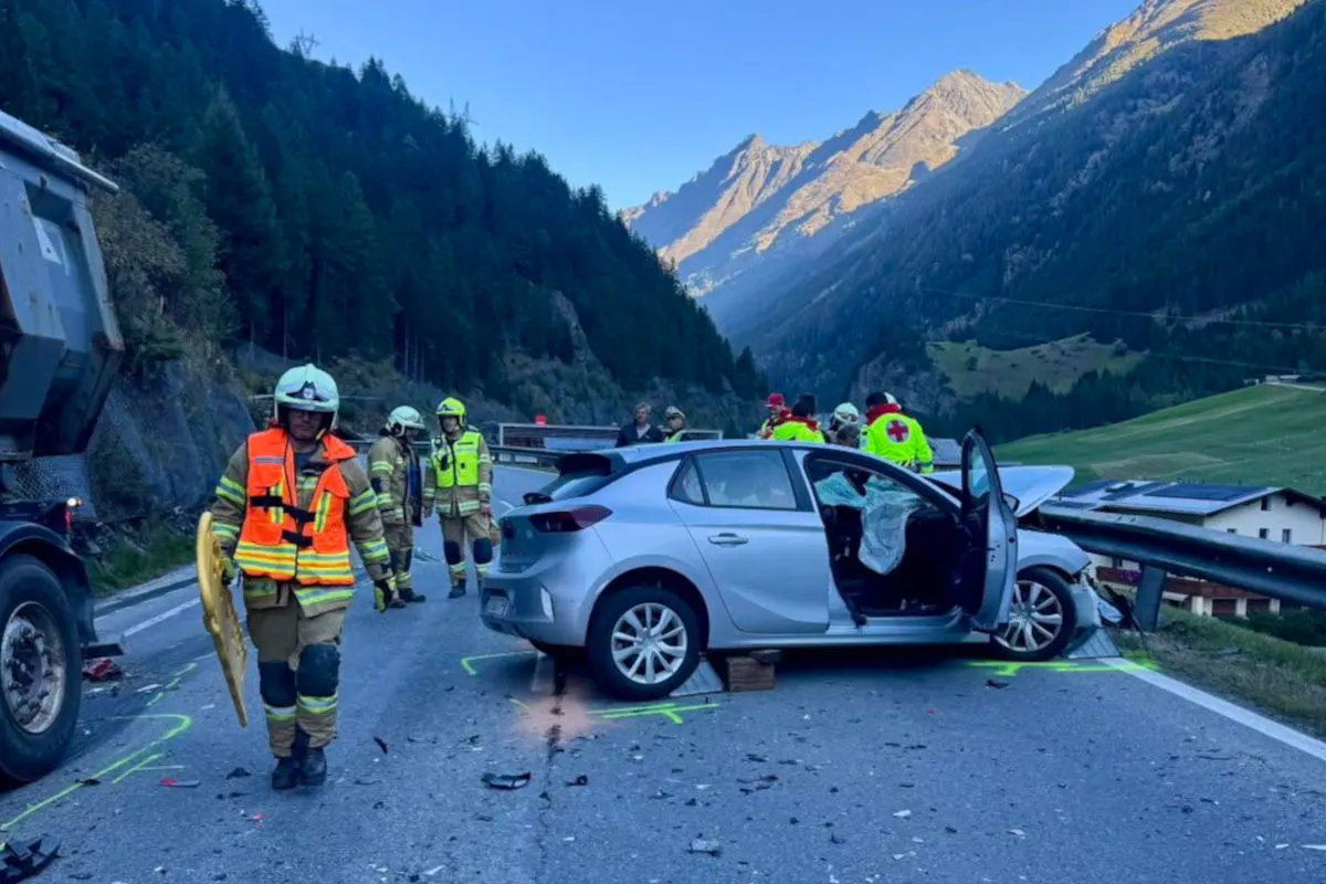Einsatzkräfte arbeiten an einer Unfallstelle in einer bergigen Gegend, ein Auto ist in die Leitplanke geprallt.