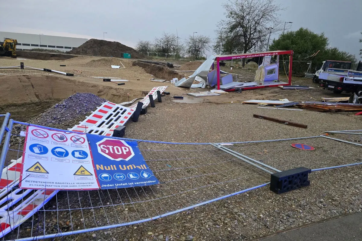Auf einer Baustelle sind Bauzäune eingerissen und Schilder umgestürzt. Im Hintergrund sind Erde und ein Fahrzeug zu sehen.