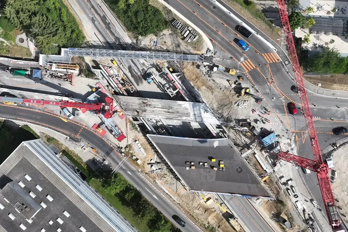 Die Luftaufnahme zeigt eine große Baustelle mit mehreren Kränen und Baufahrzeugen. Die Straßen sind teilweise gesperrt und umgeleitet.