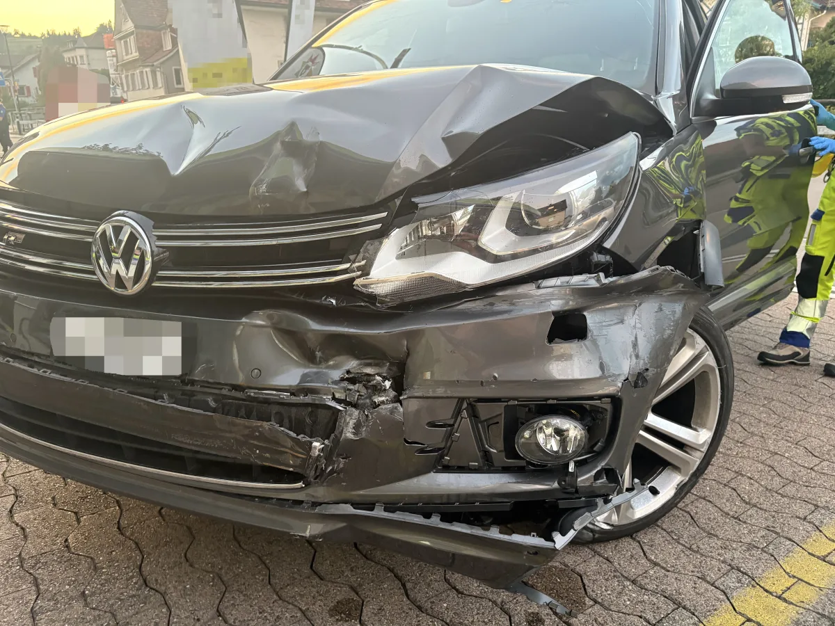 Ein silbernes VW-Fahrzeug zeigt erhebliche Schäden an der Front. Ein Notfallhelfer steht daneben.