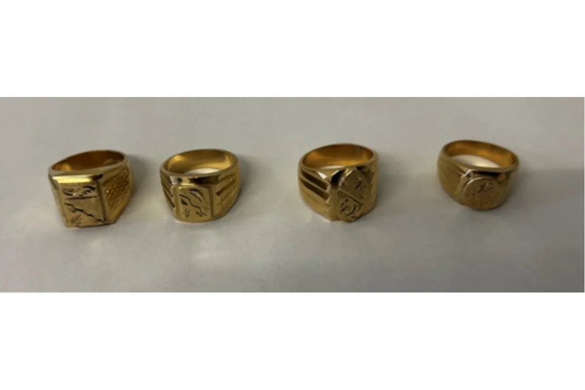 Vier goldene Ringe mit verschiedenen Gravuren liegen auf einer hellen Oberfläche nebeneinander. Jeder Ring hat ein individuelles Muster.