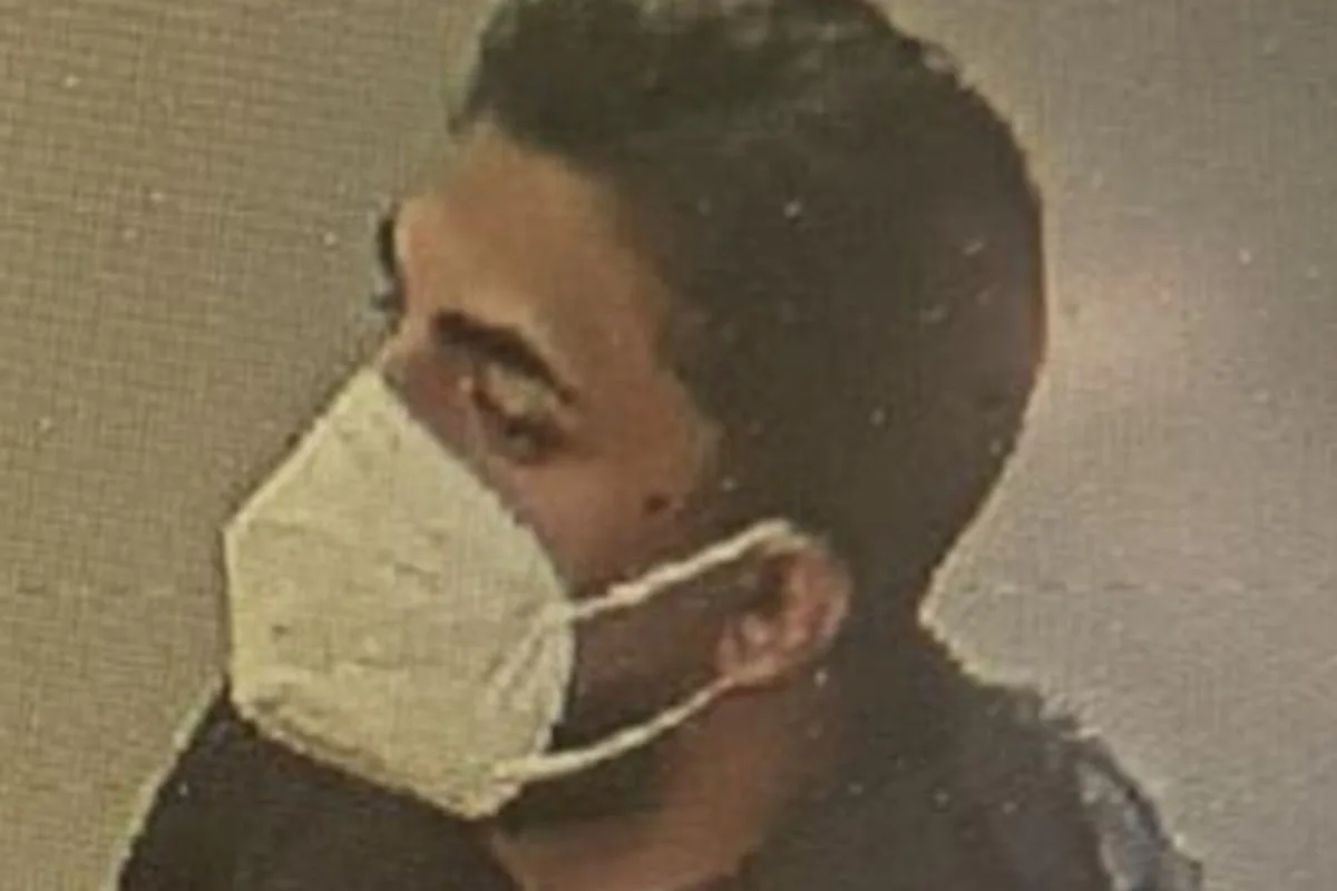 Das Bild zeigt einen Mann mit einer medizinischen Maske, wohl von einer Überwachungskamera aufgenommen, im Profil.