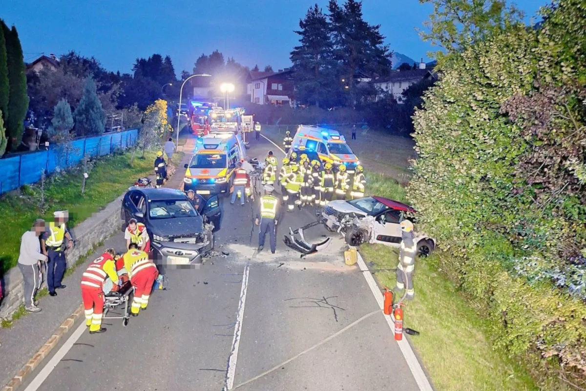 Auf einer Landstraße sind zwei stark beschädigte Fahrzeuge beteiligt. Zahlreiche Feuerwehrleute und Rettungskräfte sind vor Ort im Einsatz.